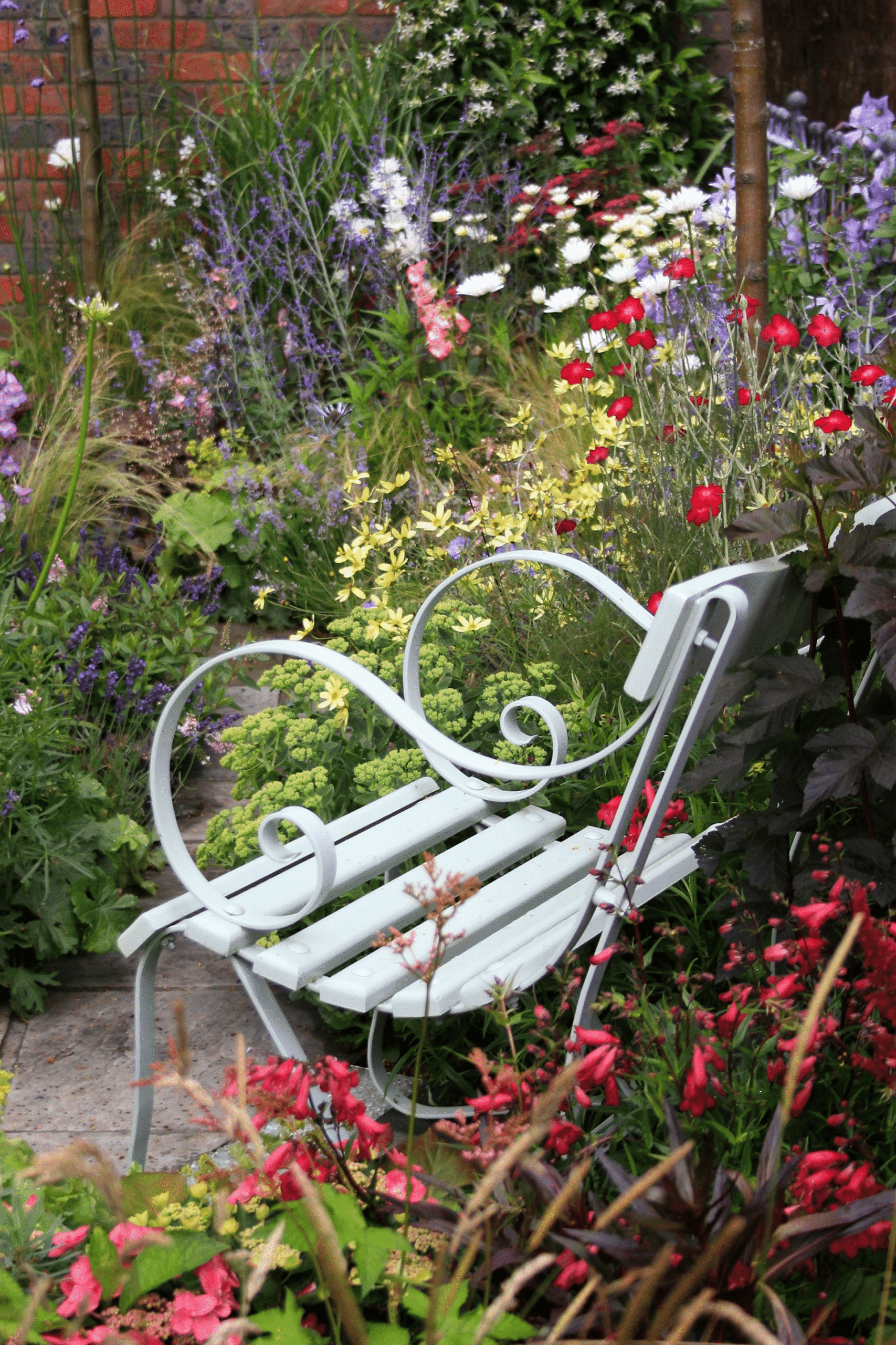 Photo of bench with flowers around it.